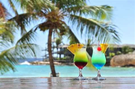 koppels genieten van cocktails aan een zwembad met uitzicht op zee