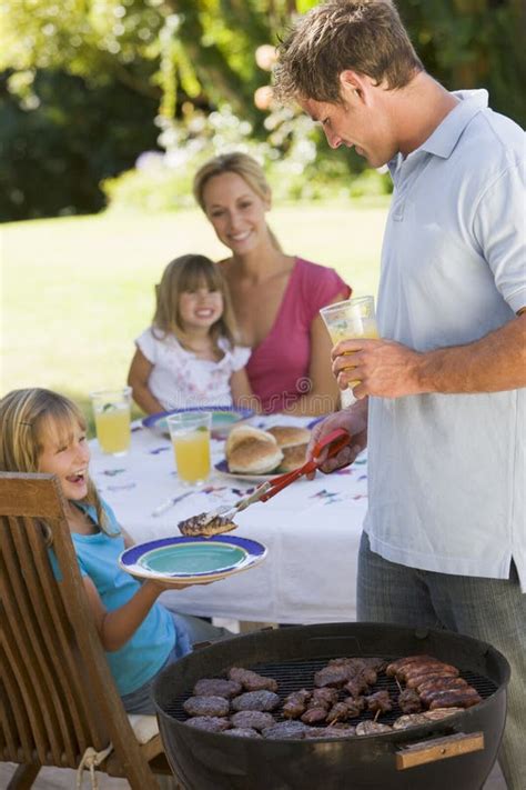 Familie genietend van een barbecue bij een bungalow.