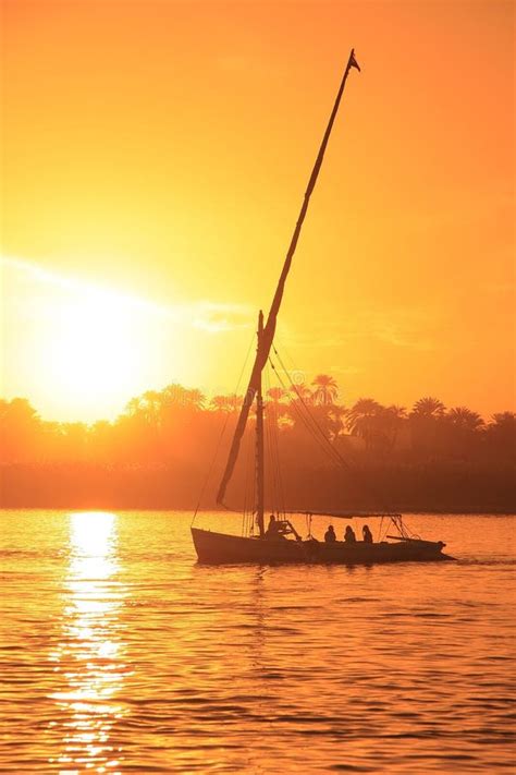 Een traditionele felukka-zeilboot vaart op de Nijl bij zonsondergang.