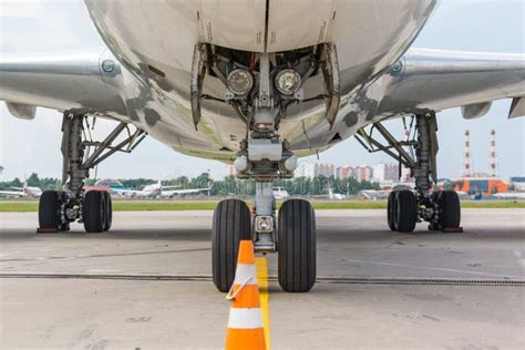 Close-up van het landingsgestel van een Boeing 777 dat de landingsbaan raakt onder winderige omstandigheden
