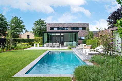 een vakantiehuis met een ruime tuin en zwembad, omgeven door groen