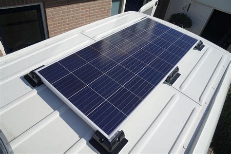 Illustratie van een camper met een zonnepaneel op het dak en een power station binnen.