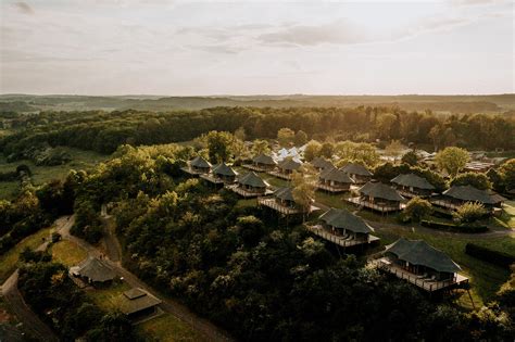 Panoramisch uitzicht op de glampingtenten van Durbuy Greenfields, omgeven door groen