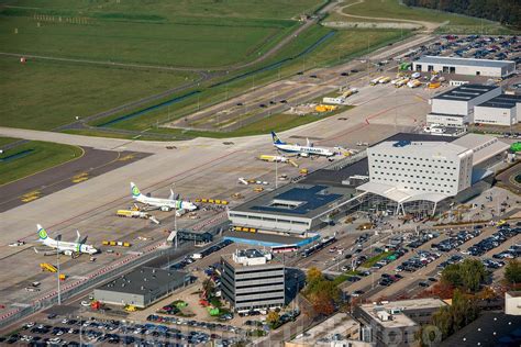 Luchtfoto van Eindhoven Airport met de terminal en parkeerplaatsen.