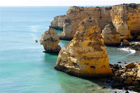 panoramisch uitzicht op een gouden strand in de Algarve, met karakteristieke rotsformaties en turquoise water