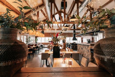 Een sfeervolle foto van het interieur van een restaurant op Schiphol met uitzicht op de startbaan.