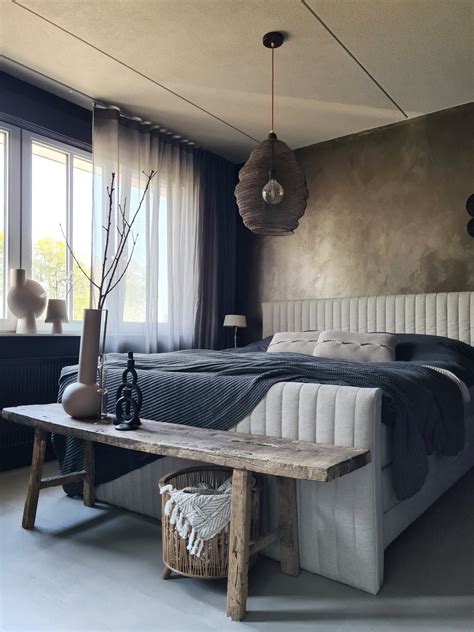Een sfeervolle slaapkamer met een luxe hoteluitstraling, waarin zachte neutrale kleuren, rijke materialen en comfortabel beddengoed centraal staan.