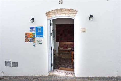 een sfeervolle binnenplaats van een boutique hotel in Vejer de la Frontera, met terracotta potten en bloeiende bougainville