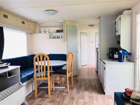 Detailfoto van een stacaravan met luifel, keukenblok en zitgedeelte