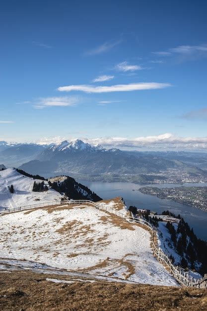 Panoramisch uitzicht op een besneeuwd Zwitsers berglandschap met de stad Luzern in de verte.