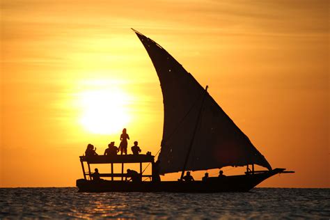 een foto van een traditionele Maledivische dhow boot bij zonsondergang