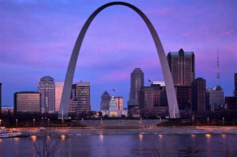 Foto van een moderne huurauto van SIXT geparkeerd voor de Gateway Arch in St. Louis.