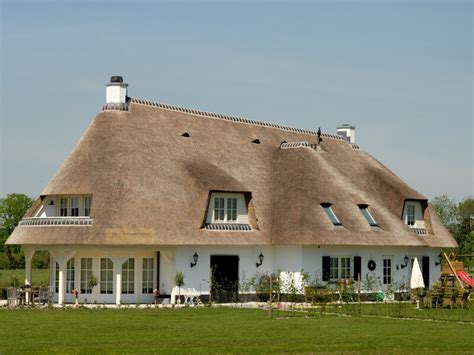 Impressionistische weergave van een vakantiehoeve met rieten kap, omringd door groen.