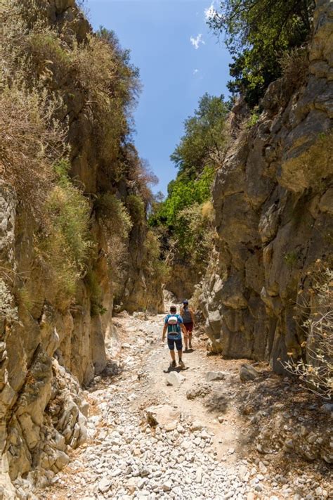 Wandelaars die door de smalle Imbros Gorge lopen, omringd door hoge rotswanden