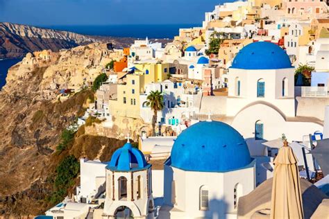 Panoramisch uitzicht op de witte huisjes en blauwe koepels van Oia, Santorini, met de Caldera op de achtergrond