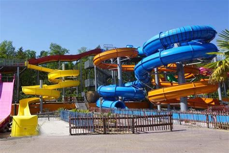 Familie genietend van waterpret in een waterpark met kleurrijke glijbanen en spetterende fonteinen.