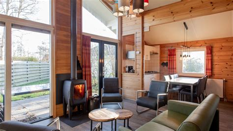 Interieurfoto van de lichte woonkamer met houtkachel en schuifpui naar het terras.