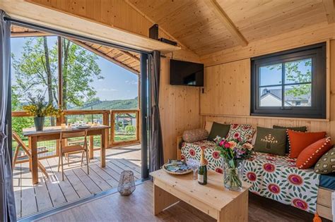 Interieurfoto van een gezellige chalet slaapkamer met houten elementen en een balkon met bergzicht