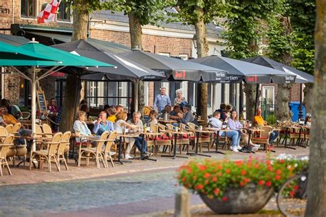 Gezellig terras van een restaurant op een vakantiepark met uitzicht op groen