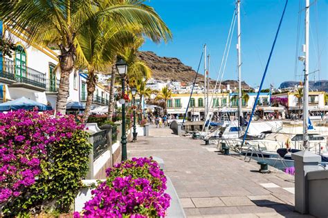 Panoramisch uitzicht over de haven van Puerto de Mogán met witte huisjes en kleurrijke bloemen