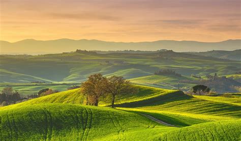 Luchtfoto van de luchthaven Siena-Ampugnano met in de verte glooiende Toscaanse heuvels.