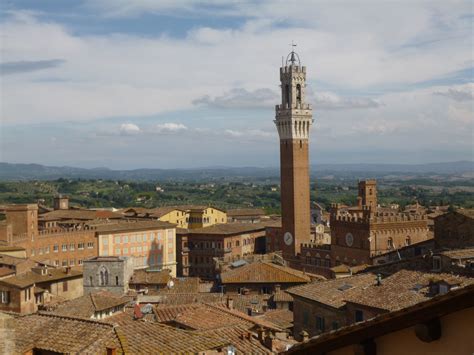 Panoramisch uitzicht over de middeleeuwse stad Siena met de Torre del Mangia op de voorgrond.