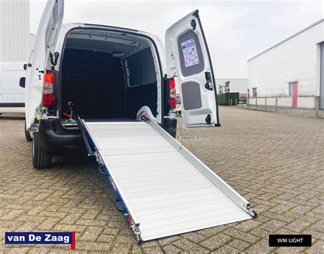 Een rolstoeltoegankelijke taxi met een open achterklep en oprijplaat