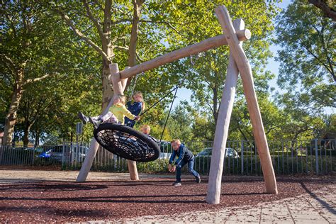 Kinderen spelen op een kleurrijke speeltuin met speeltoestellen zoals een luchttrampoline