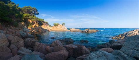 Panoramisch uitzicht over de ruige kustlijn van Costa Paradiso met de turquoise zee en rode rotsformaties.