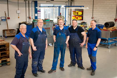Interieur van een moderne autowerkplaats met monteurs aan het werk