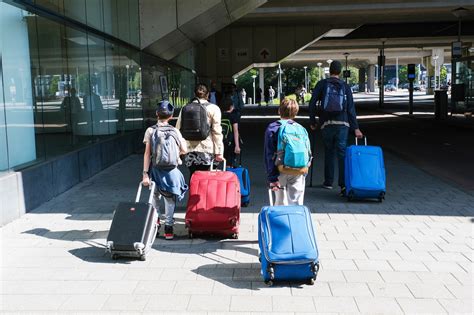 Foto van bagagemedewerkers die koffers in- en uitladen bij een vliegtuig.