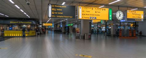 Interieur van de aankomsthal van Antwerp Airport met informatiebalies van autoverhuurbedrijven