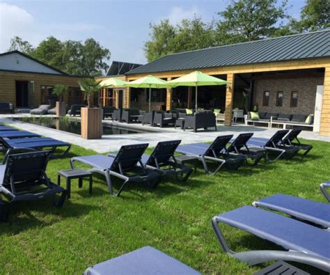 Ontspanningsruimte met zwembad en ligweide in Dunez Resort, Drunen