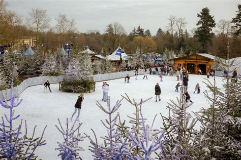 Een sfeervolle foto van Winter Laguna met een schaatsbaan, kerstbomen en de Almhut.