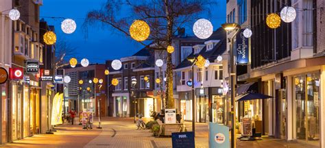 Een winterse straat in Toverland met veel kerstverlichting en een gigantische pakjestoren.