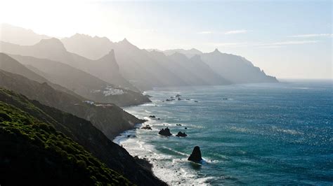 Panoramisch uitzicht op de kustlijn van Tenerife met een boot op zee.