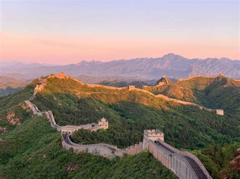 Panoramisch uitzicht op een sectie van de Chinese Muur, omringd door glooiende heuvels.