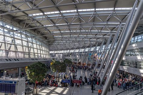 Interieurfoto van de moderne terminal van Düsseldorf Airport met winkels en zitgelegenheden.
