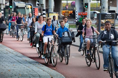 Groep fietsers die door een park in Valencia rijden, met de moderne architectuur op de achtergrond