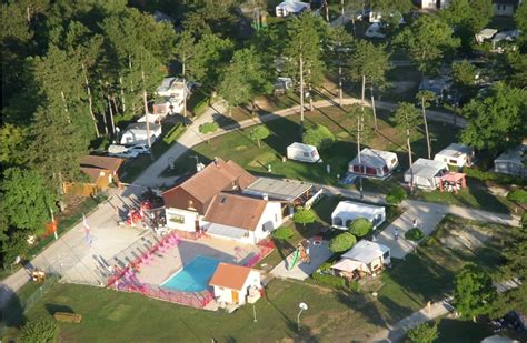 Overzicht van een camping met zwembad en chalets in een bergachtige omgeving