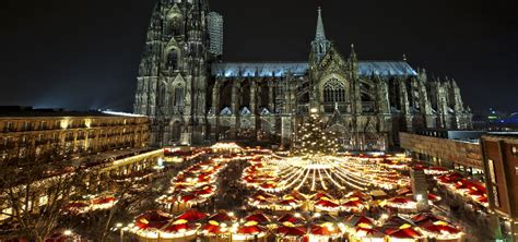 De imposante Dom van Keulen verlicht tijdens de kerstperiode, met de kerstmarkt op de voorgrond