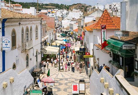 Sfeervolle klinkerstraat in het oude centrum van Albufeira met witte huisjes en bloemen