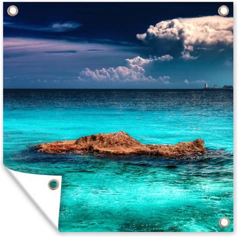 Een schilderachtig strand in Sorrento met helderblauw water, rotsformaties en ligbedden.