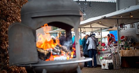Sfeervolle verlichting op een kerstmarkt met kraampjes en dennenbomen
