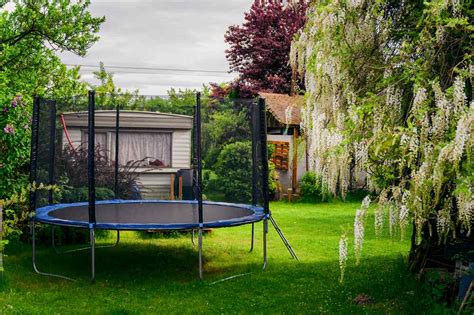 Buitenkant van een kinderbungalow met een trampoline in de tuin