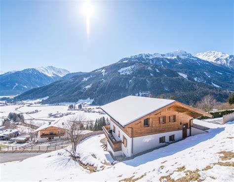 Illustratie van diverse Oostenrijkse chalets en vakantiewoningen in een besneeuwd berglandschap.