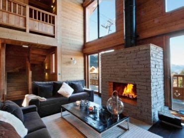 Interieurfoto van een luxe chalet met open haard en uitzicht op de bergen.