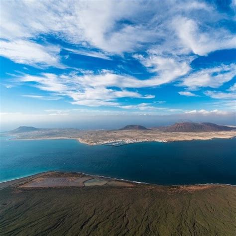 Een panoramisch uitzicht vanaf Mirador del Río over de kustlijn en het eiland La Graciosa.