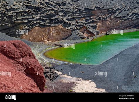 Het opvallende groene water van Lago Verde (Charco de Los Clicos) omringd door zwarte vulkanische rotsen.