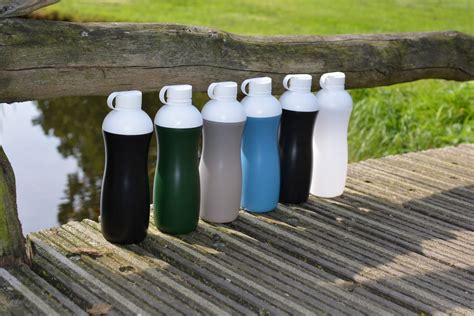 Een persoon die een herbruikbare waterfles vult uit een grotere waterkan, om duurzaamheid en gemak te benadrukken.